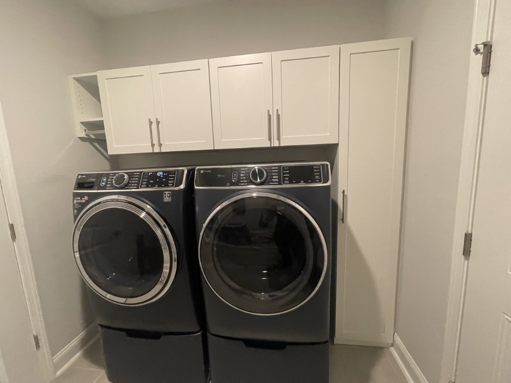 Laundry room storage cabinets with dedicated hanging area for clothes